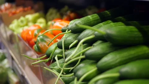 Close-up of crisp, garden-fresh cucumbers taking center stage, surrounded by a Stock Footage 314890878