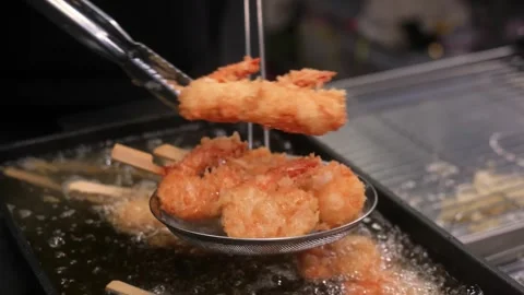 Close-up of Crispy Breaded Shrimp Skewers Deep Frying in Bubbling Hot Oil Stock Footage 337440606