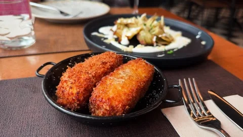 A close-up of crispy croquettes served on a plate with Serrano ham jamon serrano Stock Footage 334719737