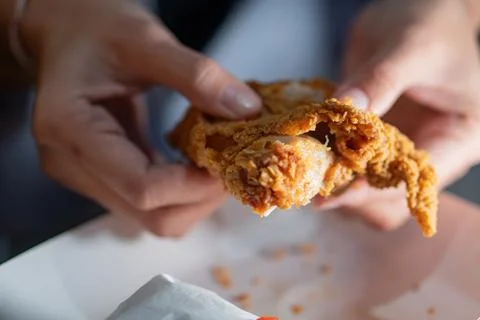 Close-Up of Crispy Fried Chicken in Hands Stock Photos