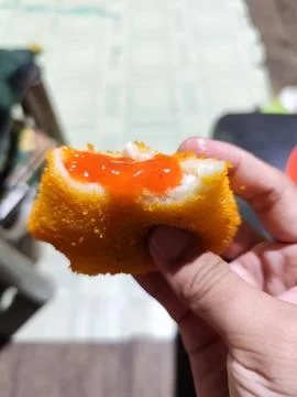 Close-Up of Crispy Fried Snack with Tomato Sauce Held by Hand Stock Photos