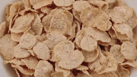 Close-up of crispy gluten-free cereal flakes with milk in a bowl slow motion Stock Footage 318447663