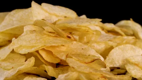 Close up of crispy golden potato chips rotating on black background for foo.. Vídeo Stock 333824878
