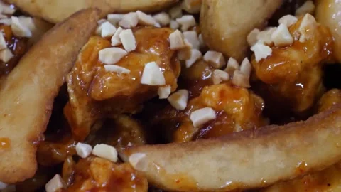 Close Up of Crispy Honey Garlic Chicken with Potato Wedges and Peanuts Video stock 343027151