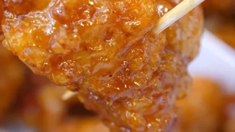Close Up of Crispy Honey Glazed Fried Chicken on a Bamboo Skewer Stock-Footage 343027657