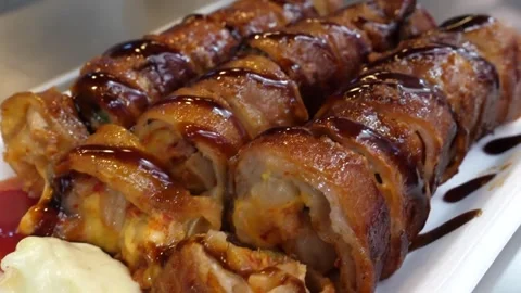 Close-Up of Crispy Pork Belly Rolls with Savory Sauce Drizzle Video stock 343588114
