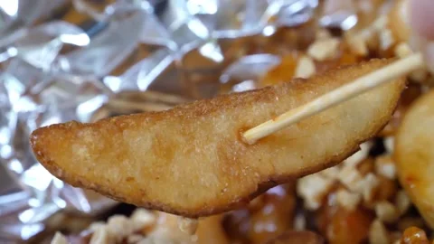 Close Up of Crispy Potato Wedge Skewered with Wooden Pick over Saucy Glazed Chic Video stock 343027077