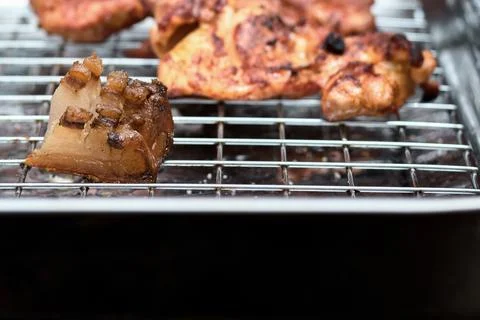 Close-up of crispy roasted bacon and pork fat pieces on a metal wire rack Stock Photos