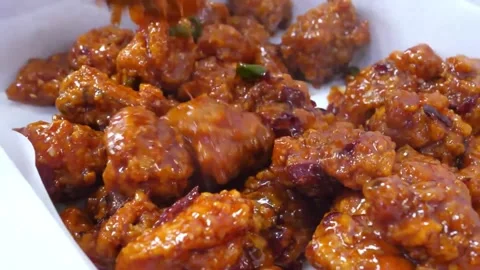 Close-up of Crispy Spicy Korean Fried Chicken Bites Glazed in Red Gochujang Sauc Video stock 343027803