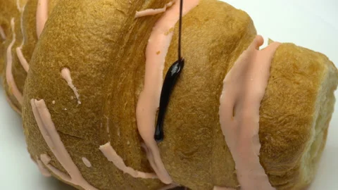 Close up croissant pouring over melted chocolate syrup. White background. Stock Footage 86574258