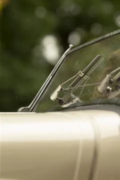 Close crop of classic car windshield and chrome wiper on cream body Stock Photos