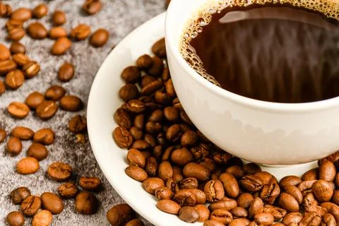 Close-up, Crop, Selective focus of coffee beans are in coffee cup saucer. Stock Photos