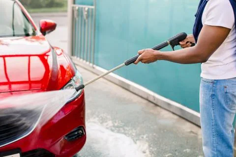 Close up cropped horizontal image of hands of African man washing his red luxury Stock Photos