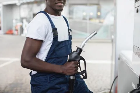 Close up cropped image of black skinned man in workwear, worker of petrol Stock Photos