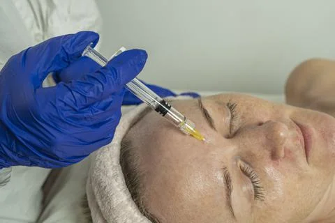 Close-up of a cropped image of a doctor's hands doing facial mesotherapy on a Stock Photos