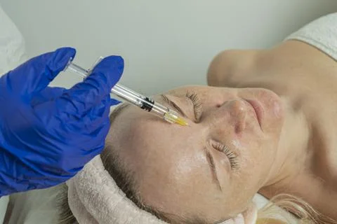 Close-up of a cropped image of a doctor's hands doing facial mesotherapy on a Stock Photos
