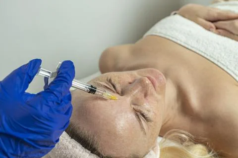 Close-up of a cropped image of a doctor's hands doing facial mesotherapy on a Stock Photos