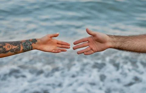Close-up cropped image of the hands of a young couple against the backdrop of Stock Photos