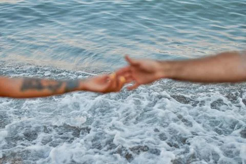 Close-up cropped image of the hands of a young couple against the backdrop of Foto stock