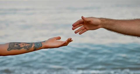 Close-up cropped image of the hands of a young couple against the backdrop of Stock Photos