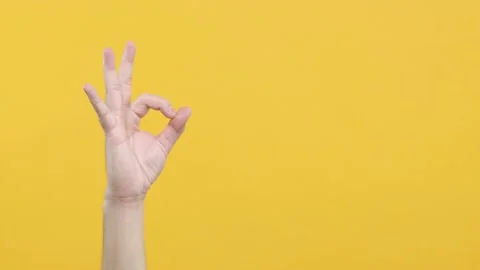 Close up cropped man hand showing OK sign okay gesture isolated on yellow backgr Stock Footage 144668607