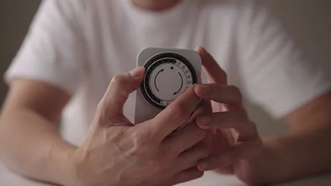 Close-up cropped shot of man setting mechanical timer switch, device used to Stock Footage 318472734