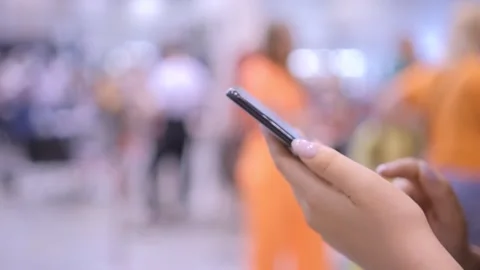 Close-up cropped shot of pretty smiling young woman using typing mobile phone Stock Footage 249954384