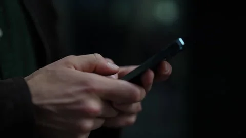 Close-up cropped shot of unrecognizable holding and using typing mobile phone Stock Footage 297623672