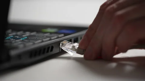 Close-up cropped shot of unrecognizable man inserting internet cable RJ 45 Stock Footage 238070895