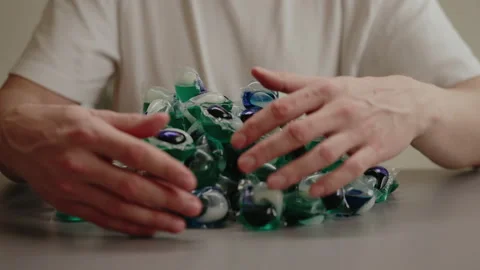 Close-up cropped shot of unrecognizable man piling up laundry capsules Stock Footage 311734702