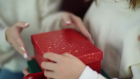 Close-up cropped shot of unrecognizable young mother giving red festive box with Stock Footage 220776428