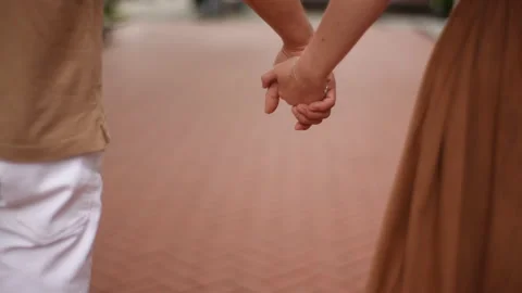 Close-up cropped shot of unrecognizable young happy couple holding hands while 스톡 동영상 227324315
