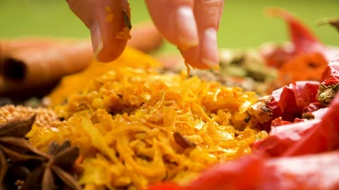 Close-up cropped view of a chef's fingers picking up brightly coloured spices Stock Footage 127992826