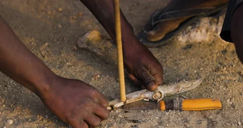 Close-up cropped view Hadza hunter-gatherer tribesmen making a fire traditional Video stock 160995496
