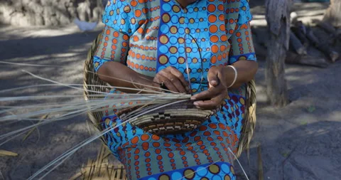 Close-up cropped view of a woman weaving traditional basket made from fan palm Stock Footage