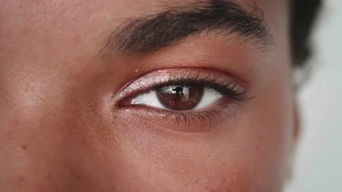 Close-up. Cropped view of a young multi-ethnic woman's brown eye blinking Stock Footage 201395399