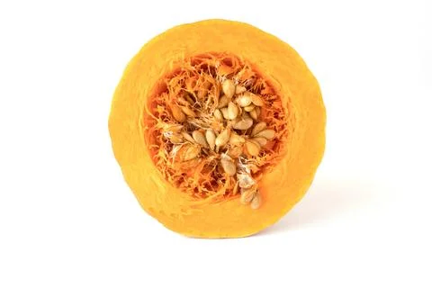 Close-up of a cross-section of an orange pumpkin with seeds on a white back.. Stock Photos