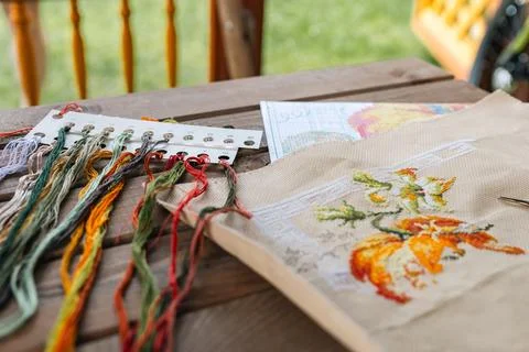 Close-up of a cross-stitch in progress. Cross-stitch with various colorful th Stock Photos