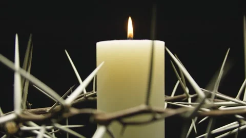 Close-up of the crown of thorns with a white burning candle. Circular filming. Stock-Footage 303955073