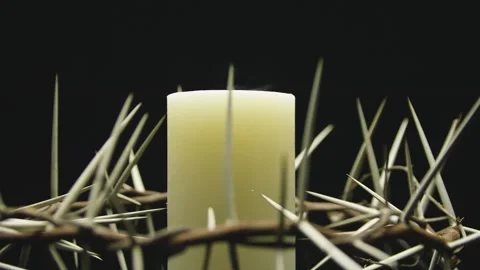 Close-up of the crown of thorns with a white burning candle. Circular filming. Stock-Footage 303955133