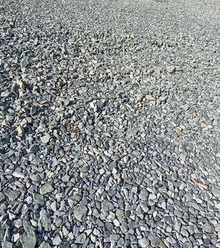 Close-up of a crushed stone surface, showcasing the rough texture and varied  Stock Photos