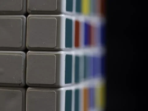 Close-up of a cube's textured surface with blurred colorful sides Stock Photos