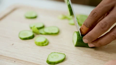 Close-up cucumber being touched by hand young Asian man on cutting board, Stock Footage 241547619