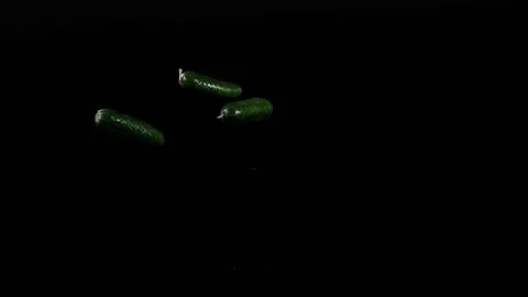 Close up at the cucumbers spinning on a black background in slow motion Stock Footage 152789343