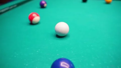 Close-up of cueball and numbered billiards on green felt with shallow depth of Stock Footage 328066311