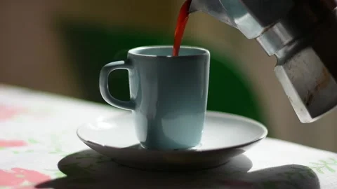 Close up on a cup and coffee poured from a mocha. Steaming coffee. Video stock 139873770