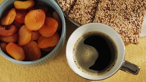 Close-up of a cup of black coffee or instant chicory with dried apricots and Stock Footage 314904961