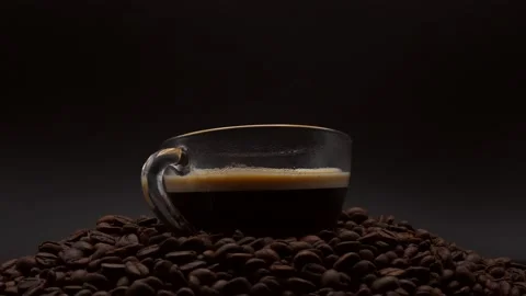 Close Up Cup Black Coffee On Roasted Coffee Bean On Black Background. Stock Footage 194614589