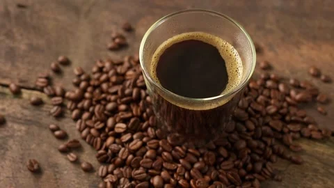 Close up cup coffee and roasted coffee bean on wooden tray rotating. Stockbeeldmateriaal 245961032