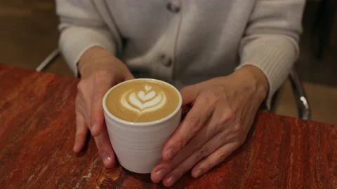 Close-up of a cup of coffee and women's hands Stock Footage 232297473